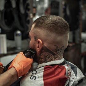 Devon Lane shaves a client's sideburns